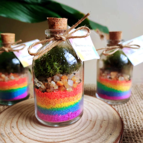 Mini terrário com camadas de areia colorida em arco-íris, com musgo no topo