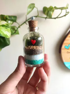 Mini terrário com areia azul e musgo, tema praia, sobre tábua de madeira